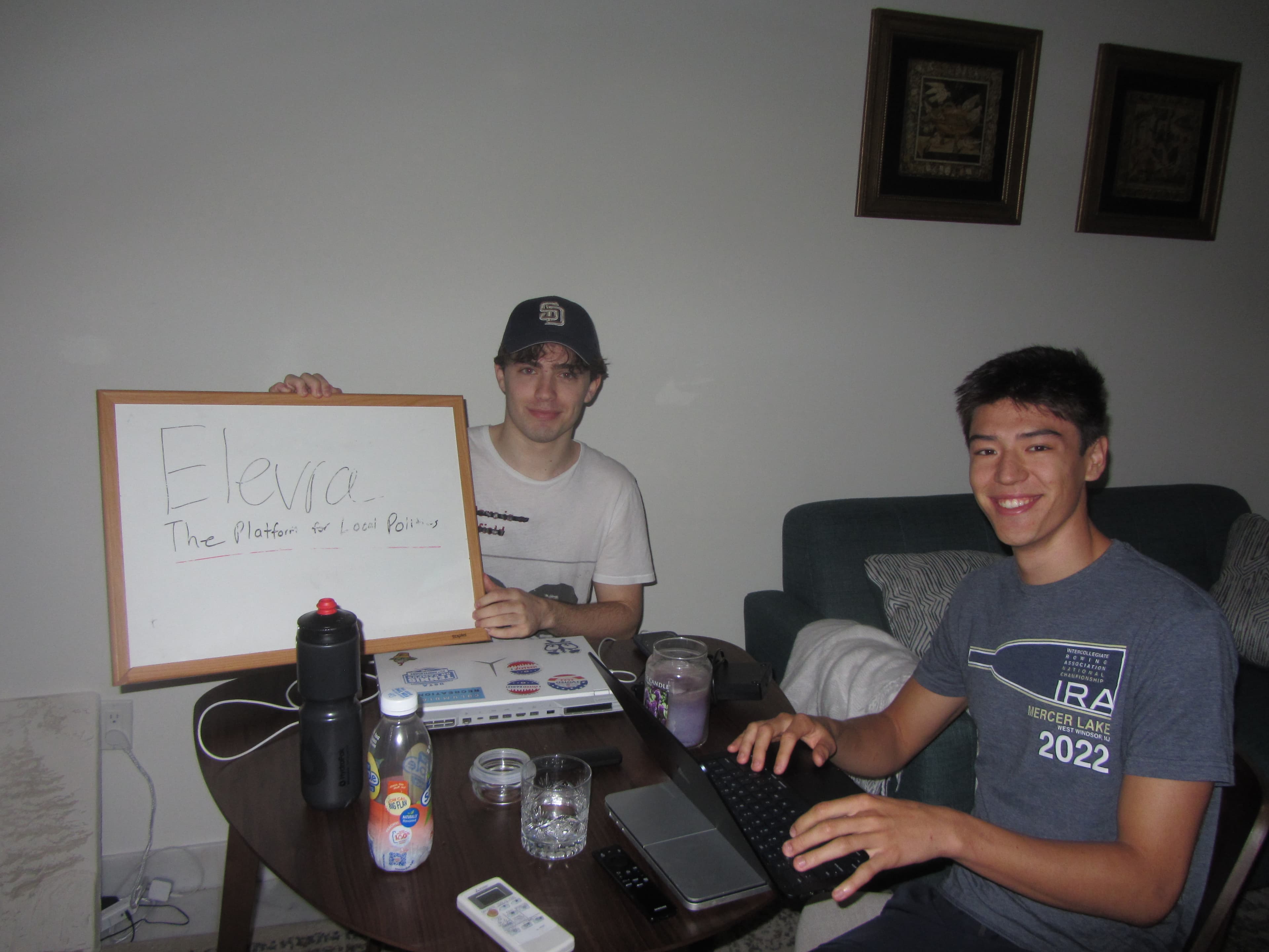 Two people holding up an Civoren sign and working on it.